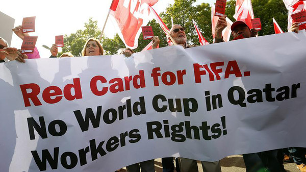 Members of the Swiss UNIA workers union display red cards and shout slogans during a protest in front of the headquarters of soccer's international governing body FIFA in Zurich