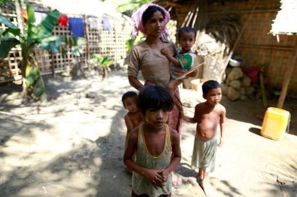 A Rohingya Muslim family, whose members have all fallen sick, poses in a village at Maungdaw