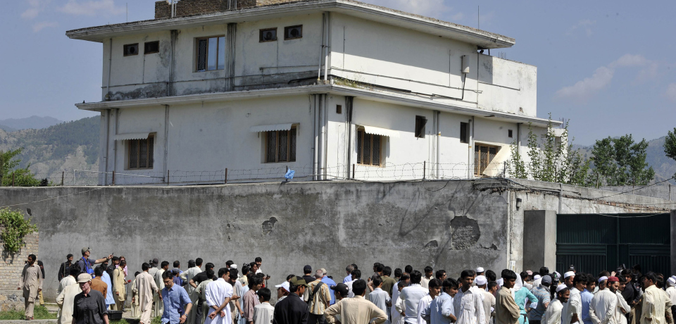 Pakistani media personnel and local residents gather outside the hideout of Al-Qaeda leader Osama bin Laden following his death by US Special Forces in a ground operation in Abbottabad on May 3, 2011. The bullet-riddled Pakistani villa that hid Osama bin Laden from the world was put under police control, as media sought to glimpse the debris left by the US raid that killed him. Bin Laden's hideout had been kept under tight army control after the dramatic raid by US special forces late May 1, 2011 in the affluent suburbs of Abbottabad, a garrison city 50 kilometres (30 miles) north of Islamabad.  AFP PHOTO/ AAMIR QURESHI (Photo credit should read AAMIR QURESHI/AFP/Getty Images)