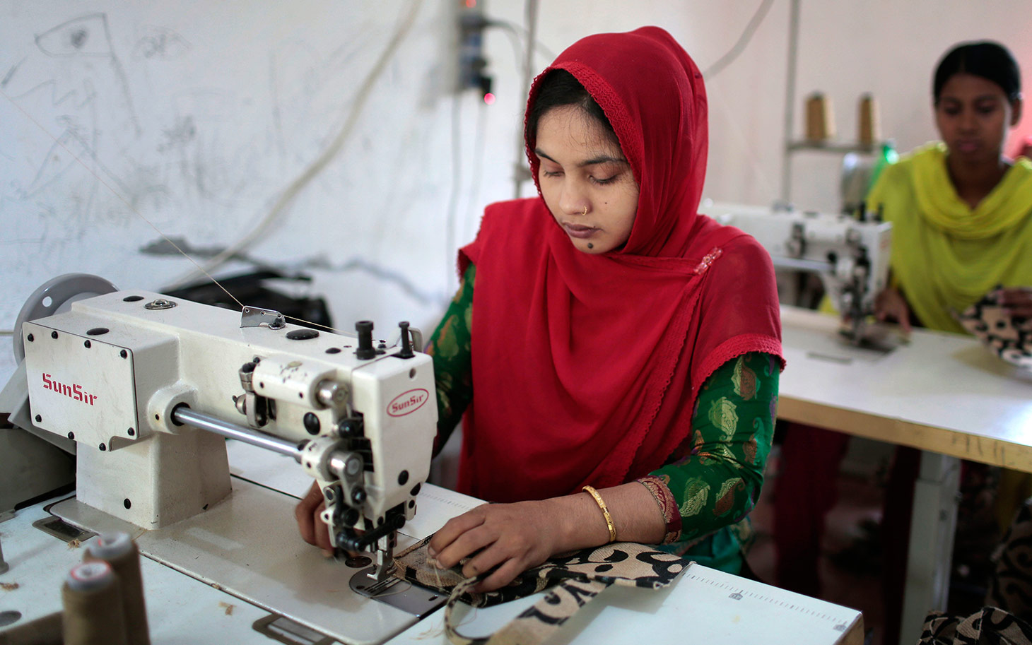 In this Monday, April 20, 2015 photo, Bangladeshi garment workers, who worked at the Rana Plaza garment factory that collapsed two years ago, work at a factory meant to rehabilitate survivors of the accident, the worst in the history of the garment industry, in Savar, near Dhaka, Bangladesh. Human Rights Watch has criticized the Bangladeshi government for failing to protect workers, saying not enough is being done to eliminate assault, intimidation and other abuses still common in the garment industry. Bangladesh suffered its worst industrial disaster when Rana Plaza, an illegally built, multistoried building located outside of Dhaka, Bangladesh's capital, collapsed in 2013 killing 1,127 people and injuring about 2,500. (AP Photo/A.M. Ahad)