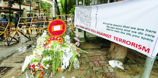 Wreaths and flowers, offered by people to pay tribute to the victims of the attack on the Holey Artisan Bakery and the O’Kitchen Restaurant, are pictured at a makeshift memorial near the attack site, in Dhaka